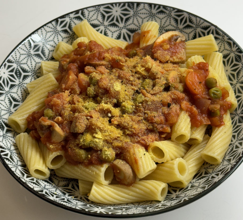 Vegan Lentil Bolognese over rigatoni pasta topped with nutritional yeast