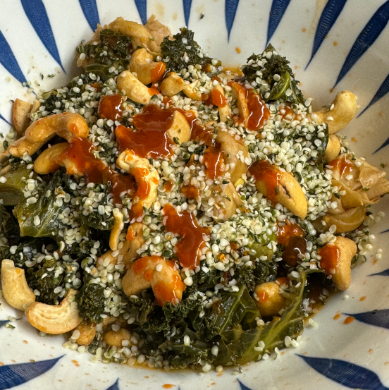 Tofu Knots with Kale and Bell Pepper served with cashews, hemp seeds, and sriracha