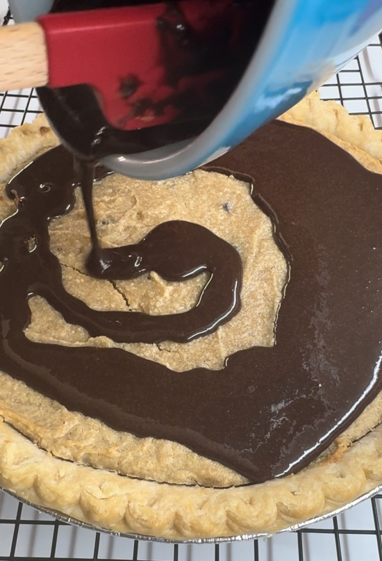 Adding the chocolate topping to the cheesecake