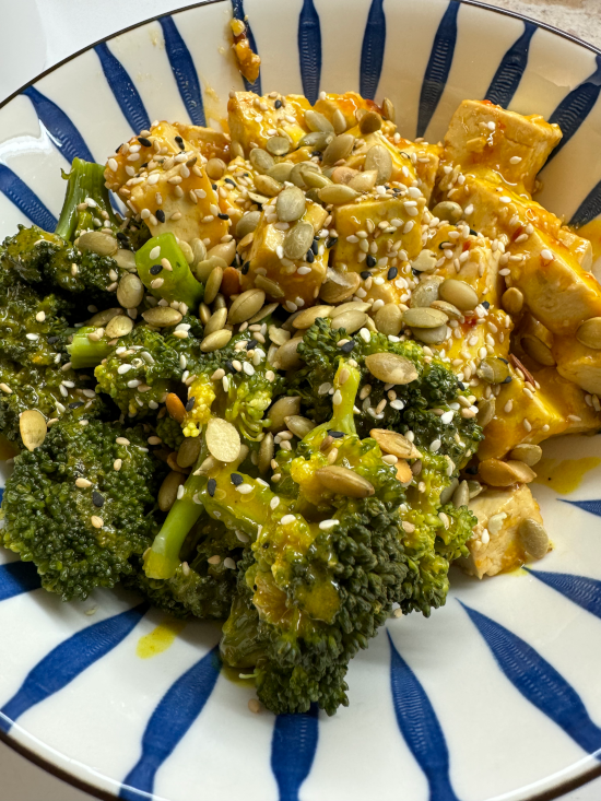 Sticky Tofu and Broccoli Quinoa Bowl with Turmeric Tahini Sauce topped with pepitas and sesame seeds