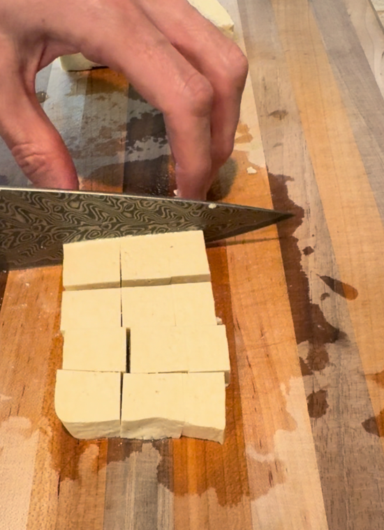 Cutting extra firm tofu into cubes