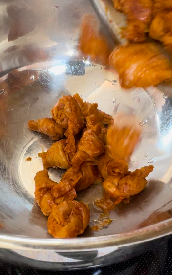 Cooked tofu knots being removed from skillet