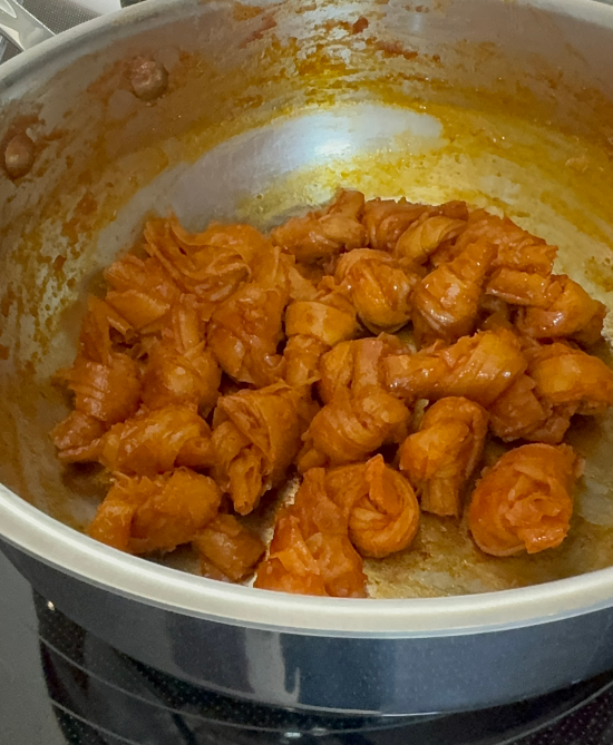 Cooked tofu knots about to be removed from skillet