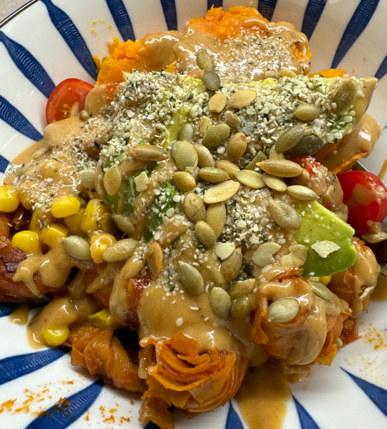 Tofu Knots and Sweet Potato Quinoa Bowl topped with Peanut Sauce, Hemp Hearts, and Pepitas