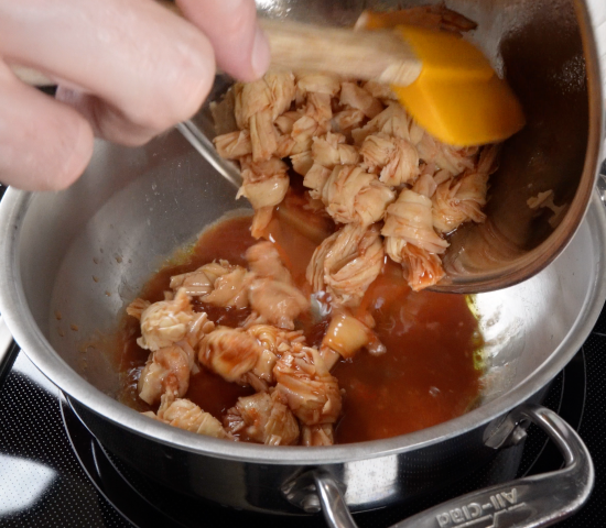 Adding tofu knots with marinade to pan