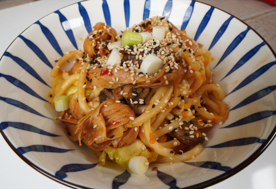 Udon Noodle Stir Fry with Tofu Knots topped with green onions and sesame seeds