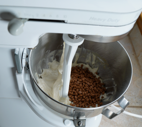 Adding the caramel chips to the stand mixing bowl