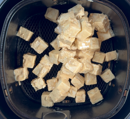 Marinaded tofu in air fryer basket