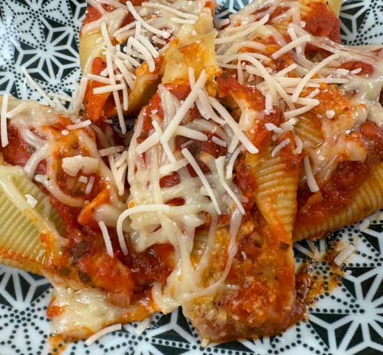 Vegan baked stuffed shells garnished with vegan parmesan