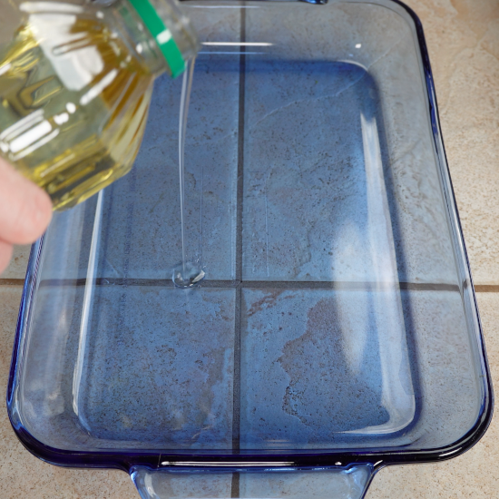 Adding canola oil to the 9 x 13 inch baking dish