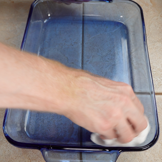 Using a paper towel to grease the baking dish