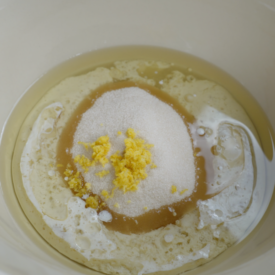 Wet ingredients, sugar, and lemon zest added to the mixing bowl. 