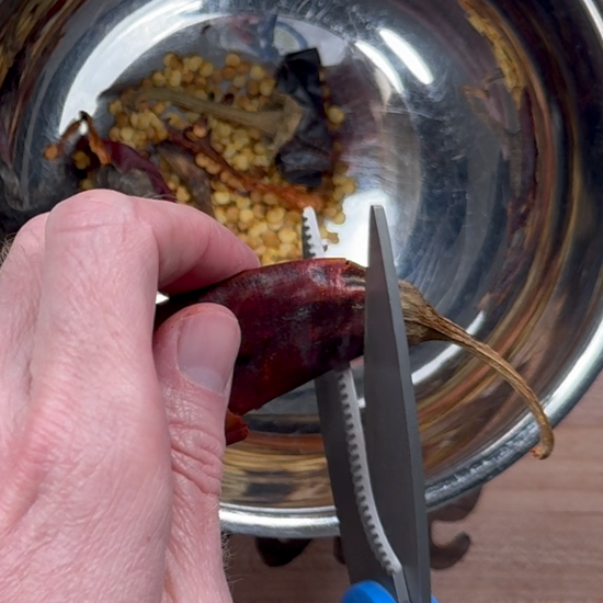 Removing the stems and seeds from the dried chiles