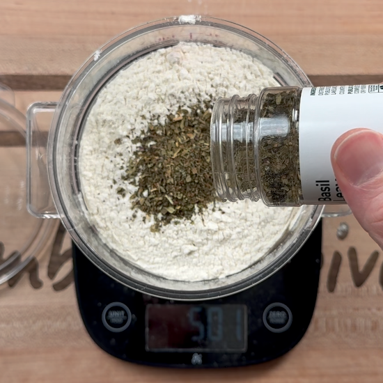 Adding the dried basil to the flour