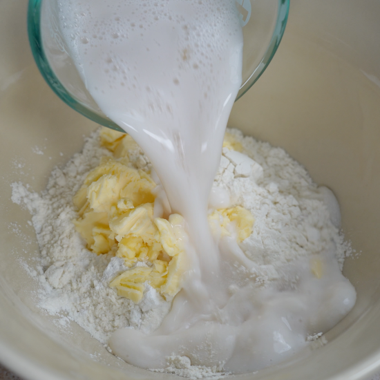 Biscuit dough wet ingredients being added to the mixing bowl
