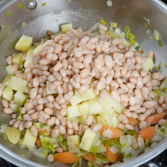 Navy beans added to the pan