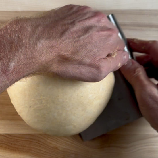 Shaping the dough with a pastry scraper. 